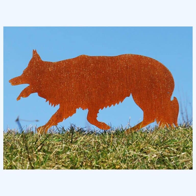 Ein Border Collie ist als Rostfigur in den Rasen gesteckt.