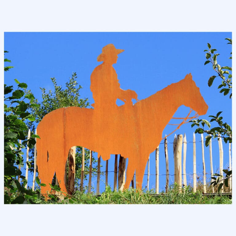 Rostiger Cowboy als Blechfigur im Rasen eingesteckt