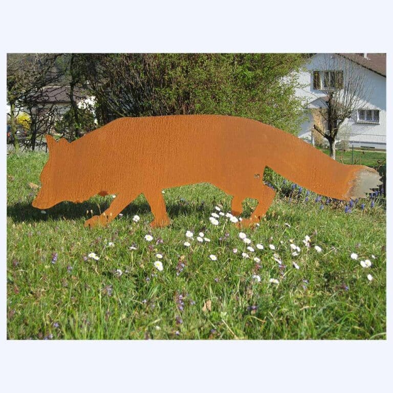 Rostiger Fuchs als Blechfigur im Rasen eingesteckt