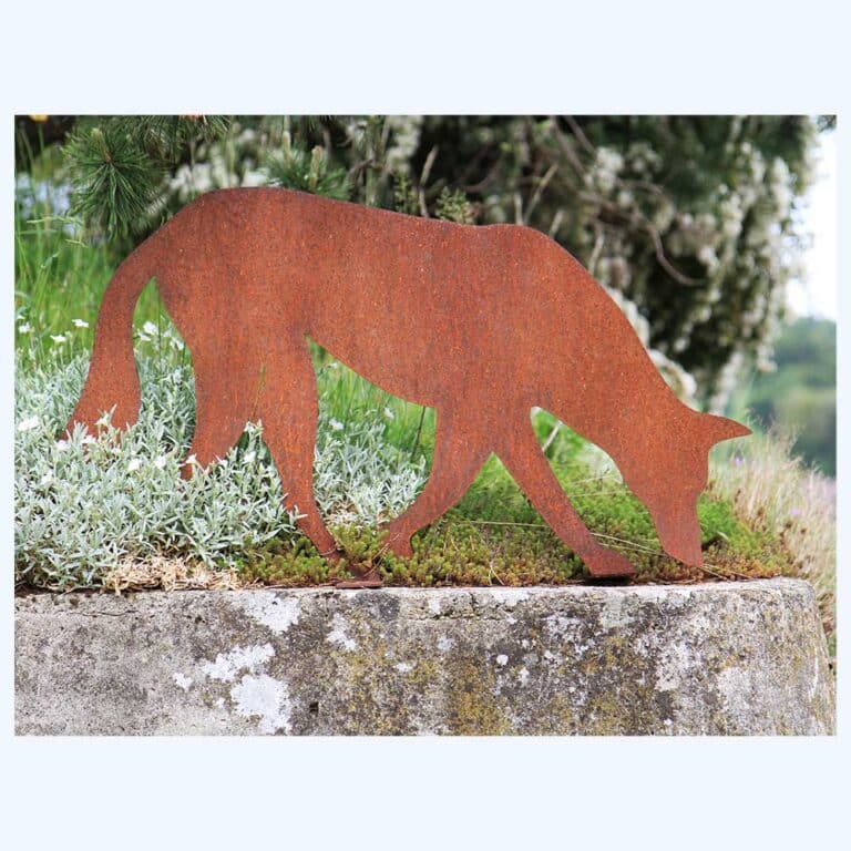 Rostiger Wolf suchend als Blechfigur im Rasen eingesteckt